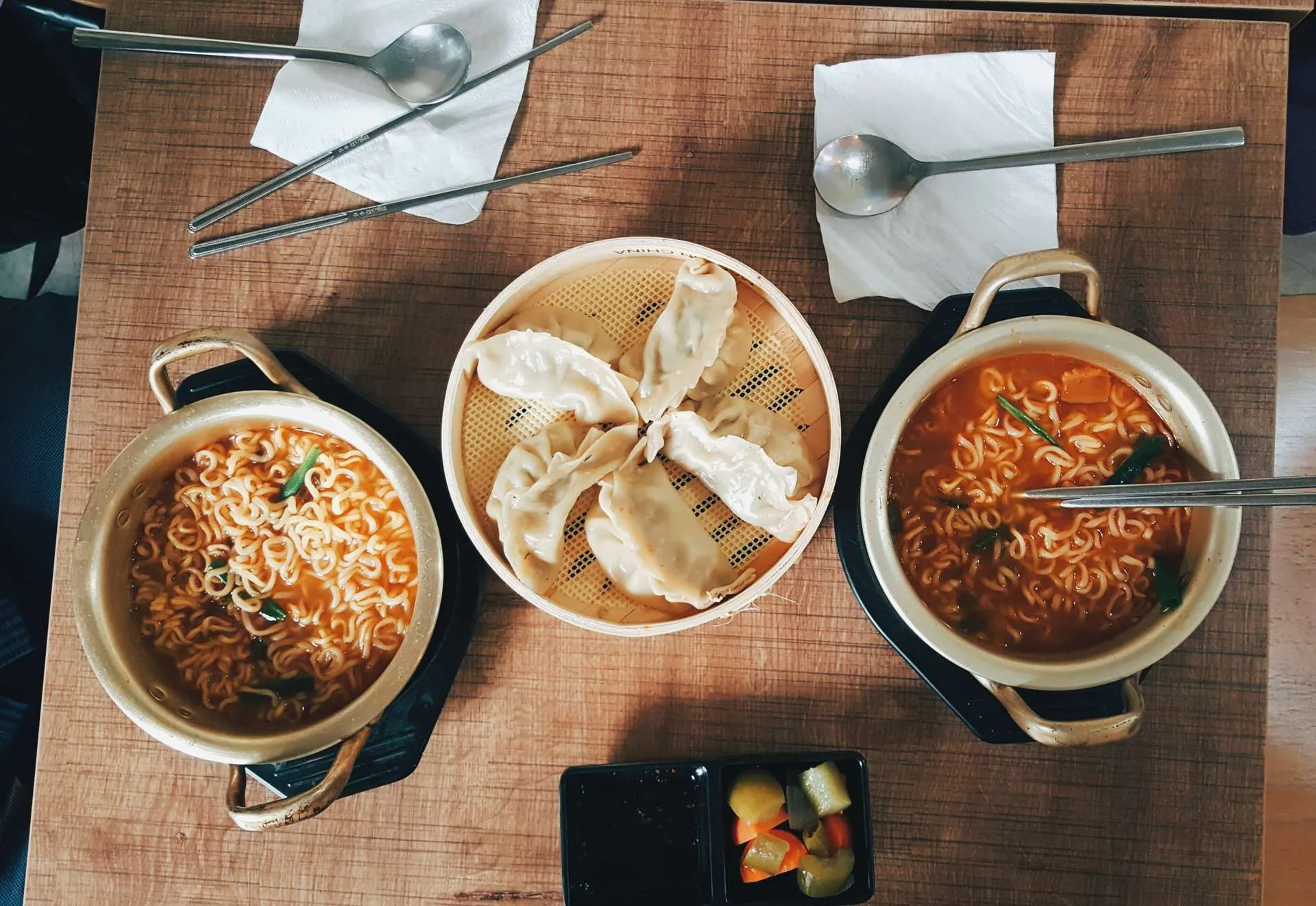 Korean ramen bowls and dumplings arranged on a table