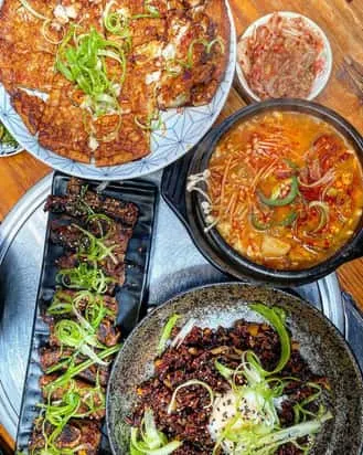 A shared spread of Korean dishes with colorful banchan
